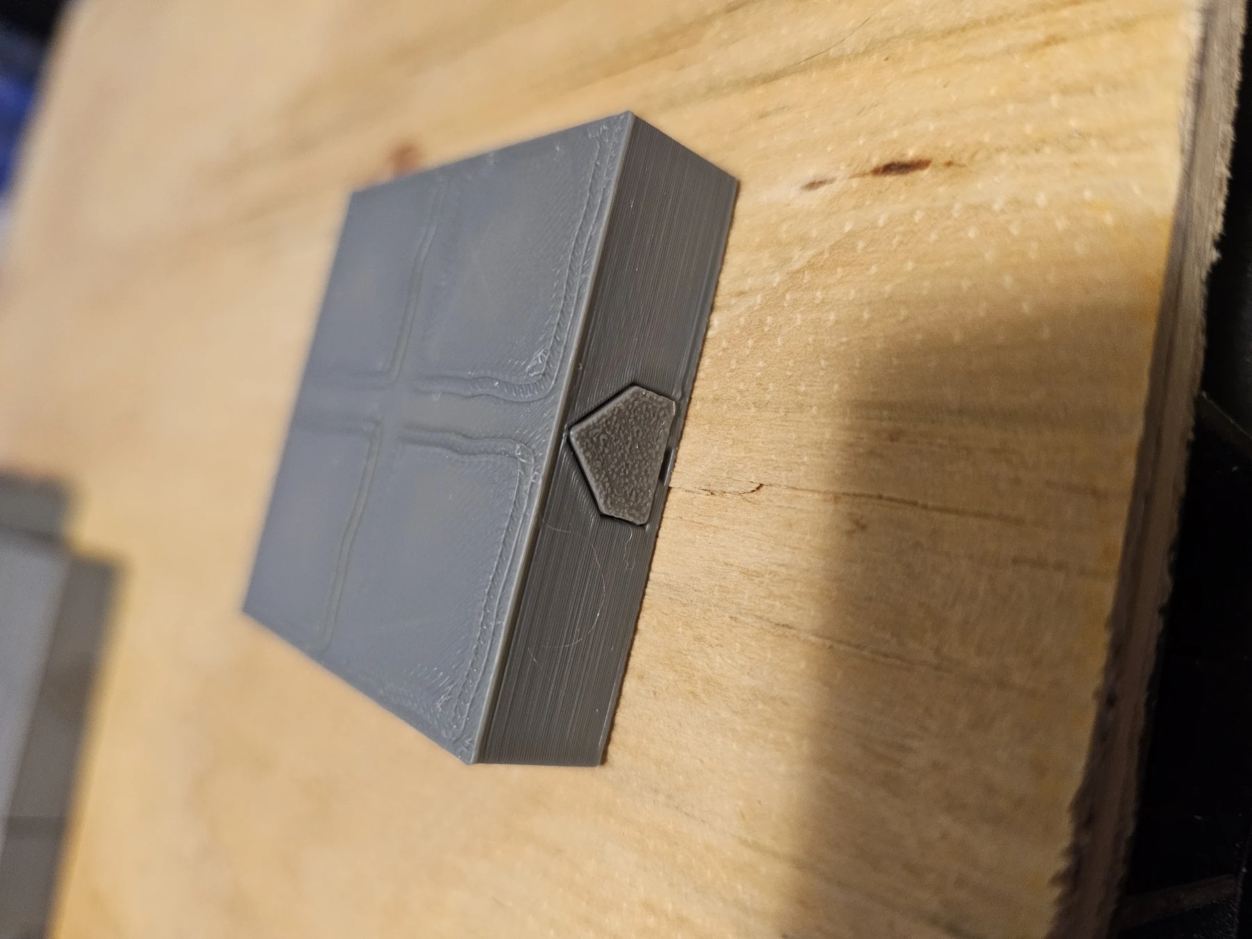 Angled product view of a finished dungeon floor tile on a wooden surface.