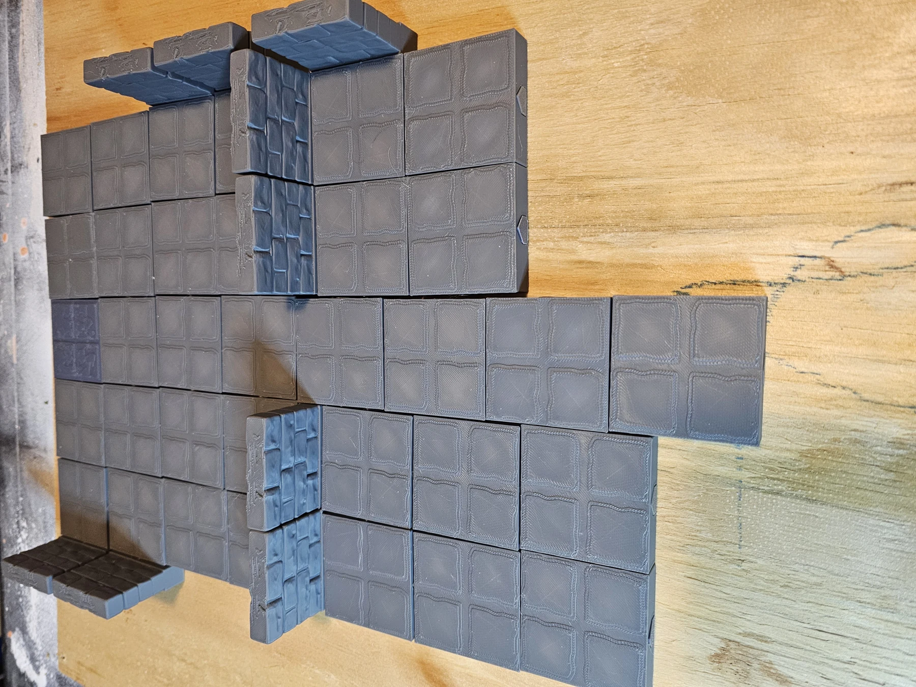 Multiple printed floor tiles assembled with wall sections on a table.