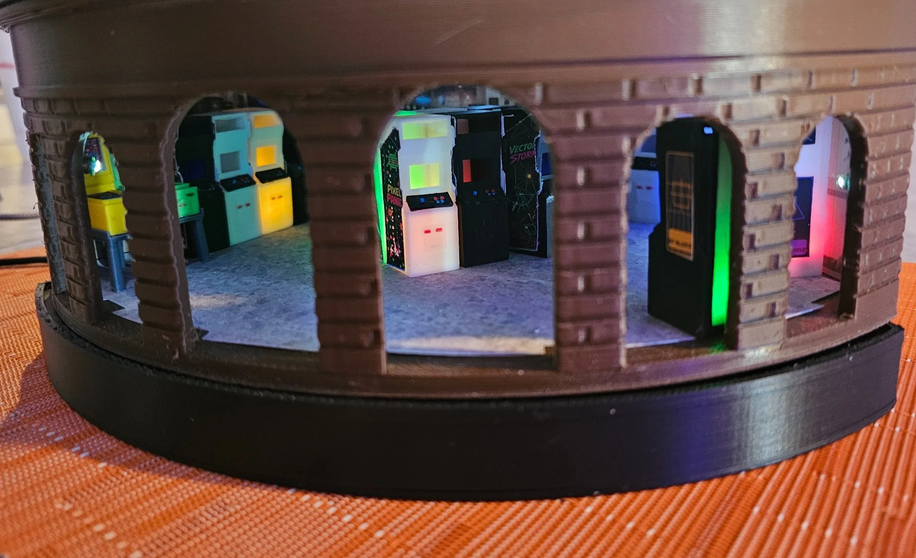 Close-up of curved lower facade with windows showing lit arcade machines inside